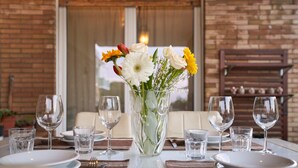 A dining table set with plates, cutlery, and a vase of flowers. - Luxurious Terrace and confort close Rome Center (Roma)