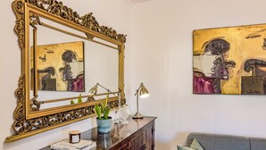 A room with a large ornate mirror, a painting, a plant, and a lamp on a wooden dresser. - Luxurious Terrace and confort close Rome Center (Roma)