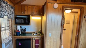 A compact kitchen with a microwave, sink, and refrigerator.