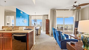 Ein modernes Hotelzimmer mit Küche, Essbereich und Balkon mit Blick auf die Stadt.