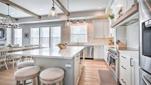 A modern kitchen with a central island, stainless steel appliances, and pendant lighting.