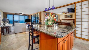 A spacious living area with a large island, a view of the ocean, and a traditional Japanese sliding door.