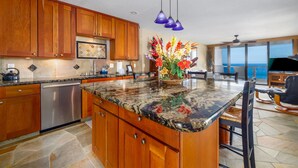 A kitchen with wooden cabinets, a stainless steel dishwasher, and a granite countertop.