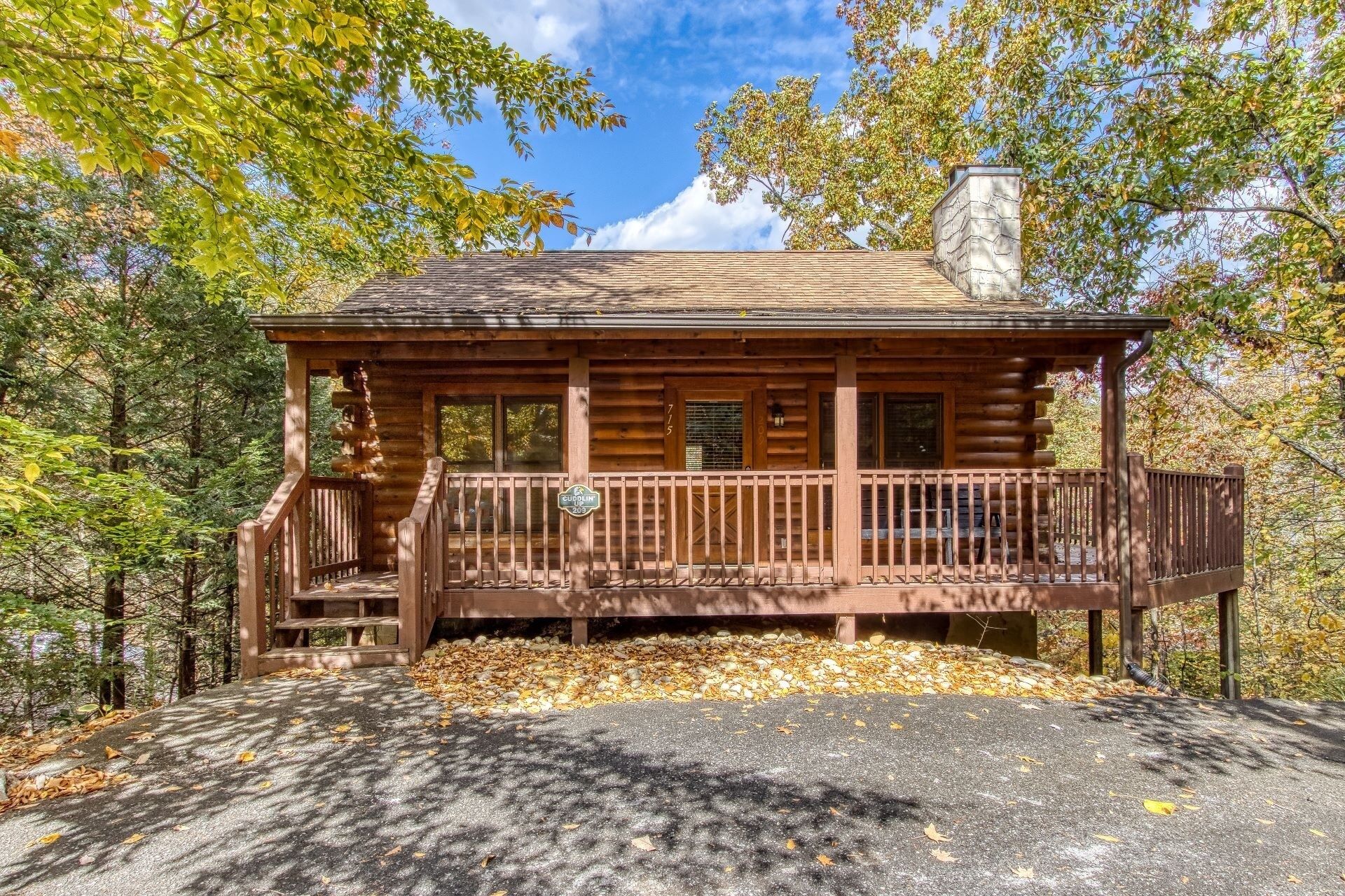 A log cabin with a porch, a chimney, and a sign indicating it is a campground.