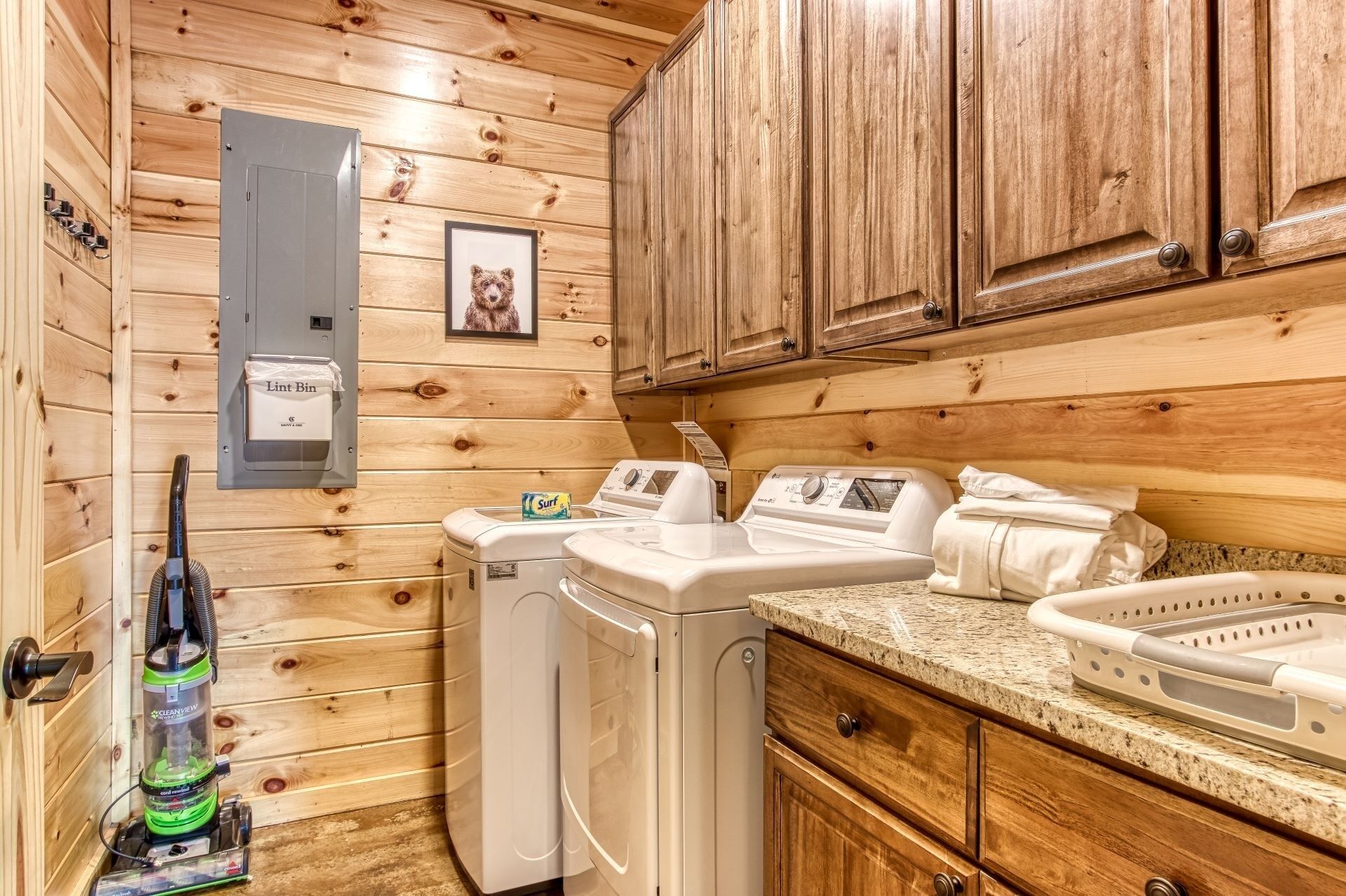 A compact laundry room with a washing machine, dryer, and a lint trap.