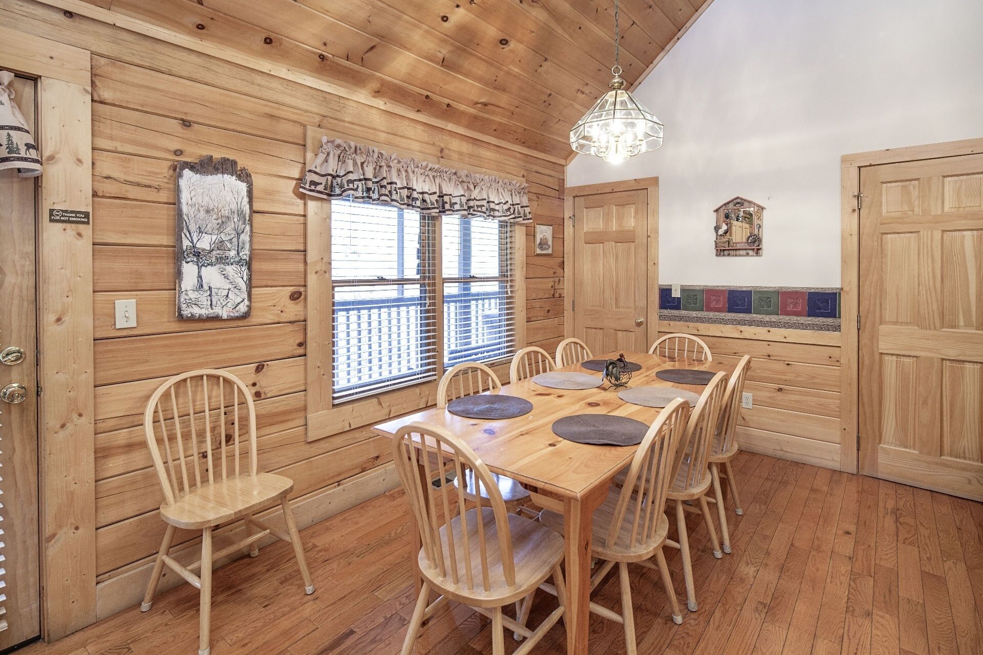 A wooden interior with a dining table set for six, surrounded by wooden chairs.