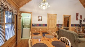 A cozy dining area with a wooden table, chairs, and a chandelier.