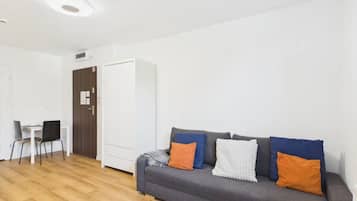 Una sala de estar moderna con un sofá gris, una mesita y dos sillas.