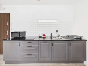 A kitchen with a microwave, coffee maker, and sink. - Super Apart Obywatelska (Warsaw)