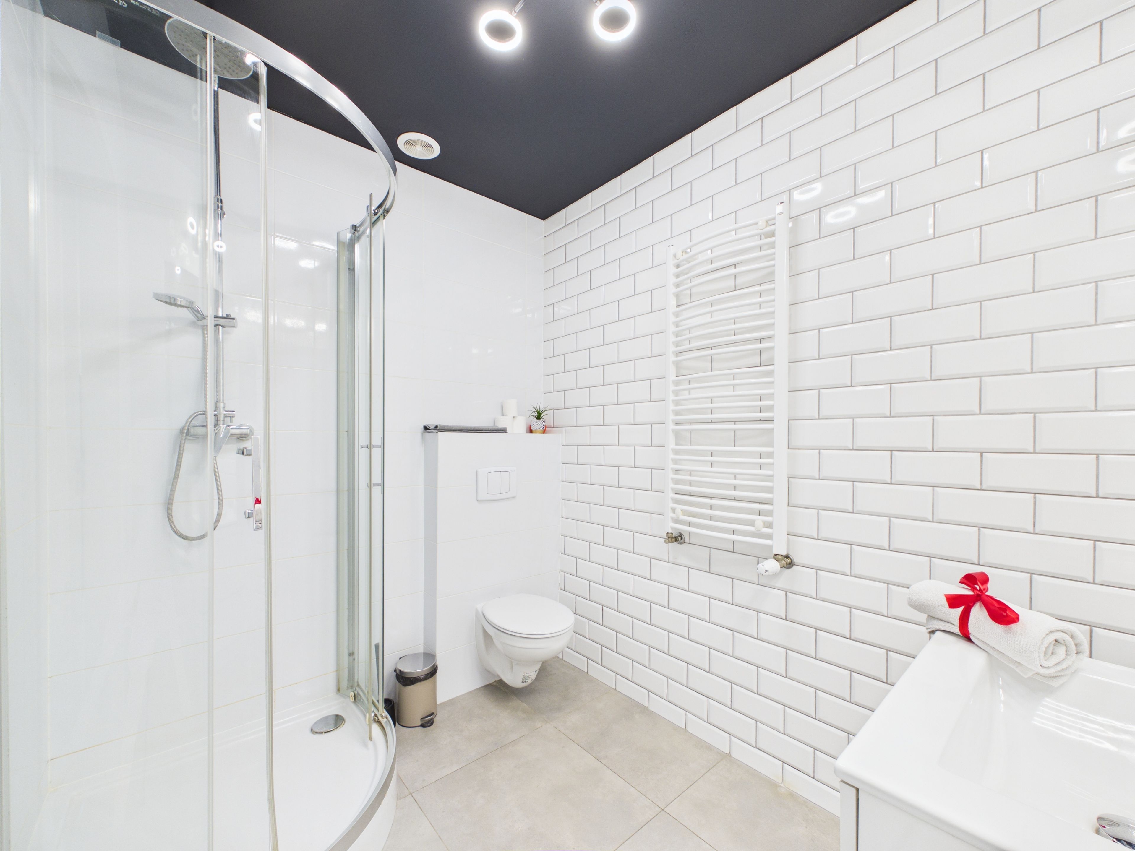 Un bagno moderno con cabina doccia in vetro, un water e un lavabo con un asciugamano.
