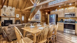 Ein gemütliches Blockhaus-Interieur mit Essbereich, Küche und Wohnzimmer.