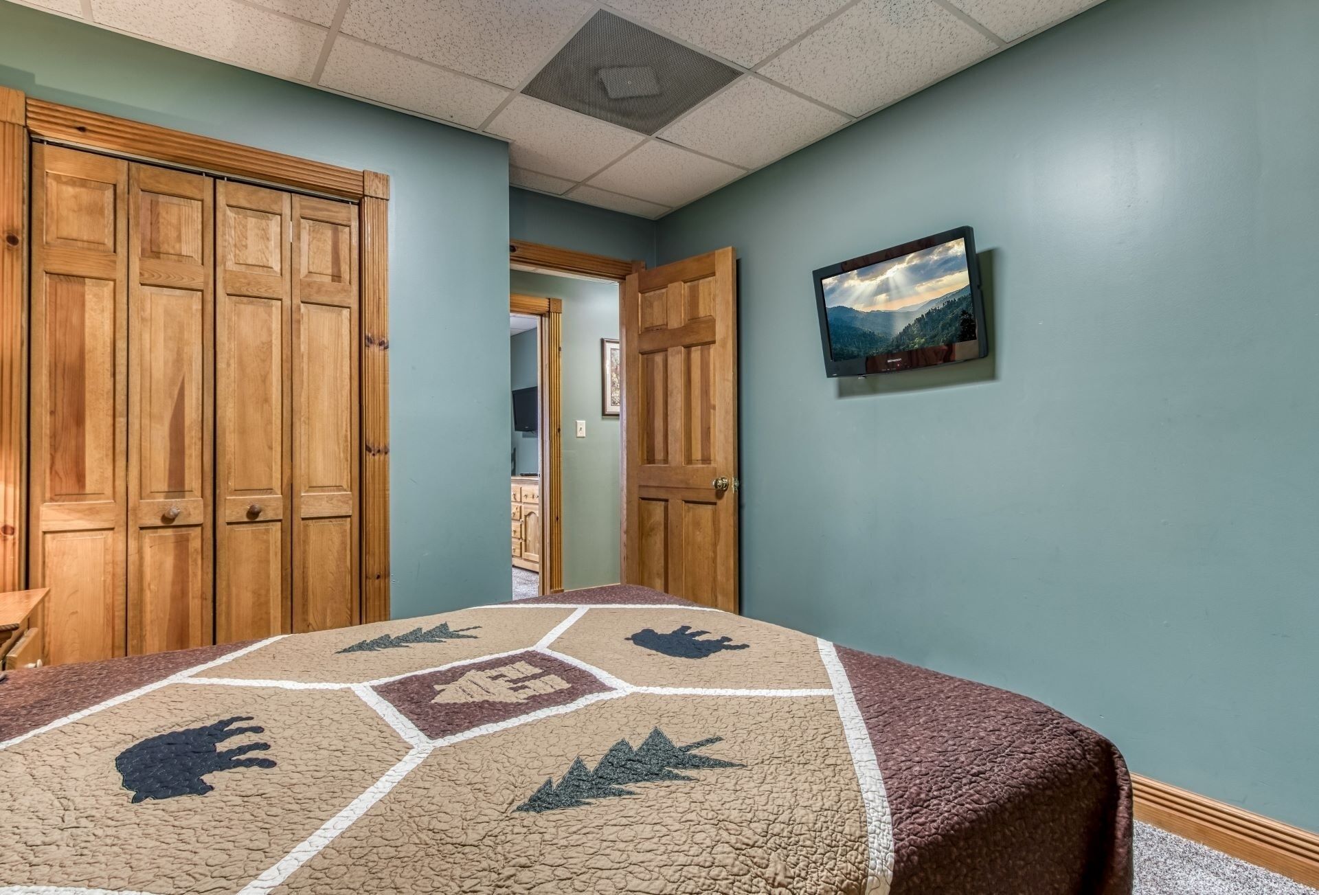 A room with a bed, wooden wardrobe, and a painting on the wall.