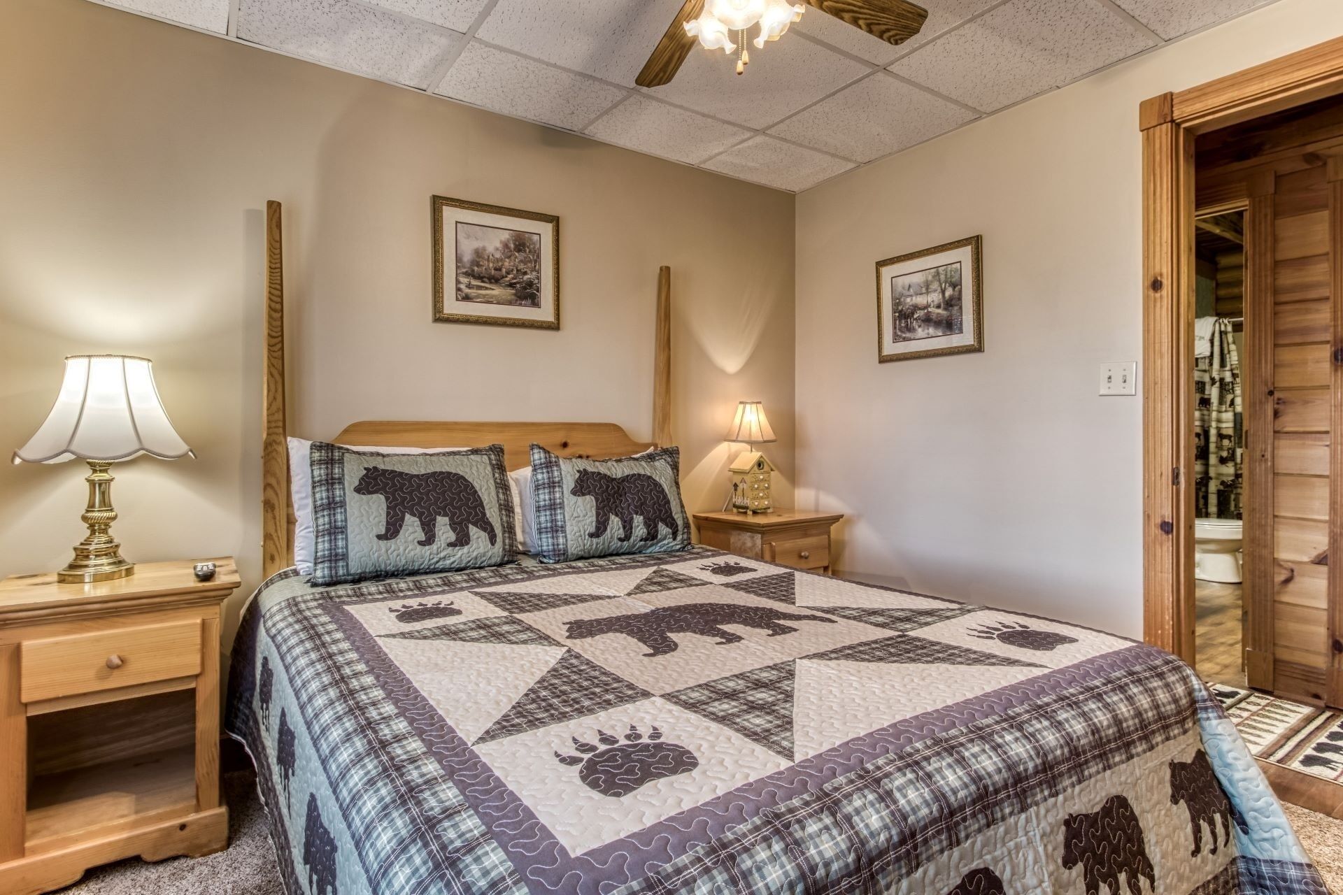 A bedroom with a bed, two bedside tables, a nightstand, a lamp, and two framed pictures on the wall.
