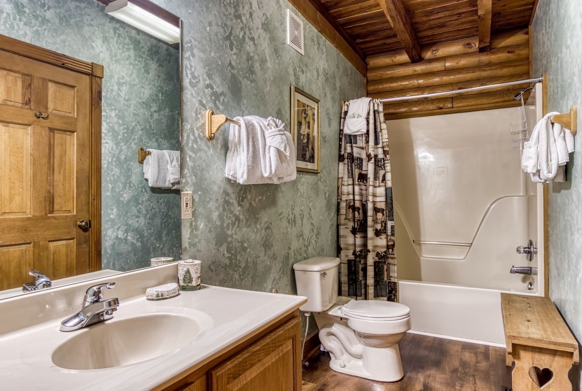 A bathroom with a wooden vanity, a sink, a toilet, and a bathtub.