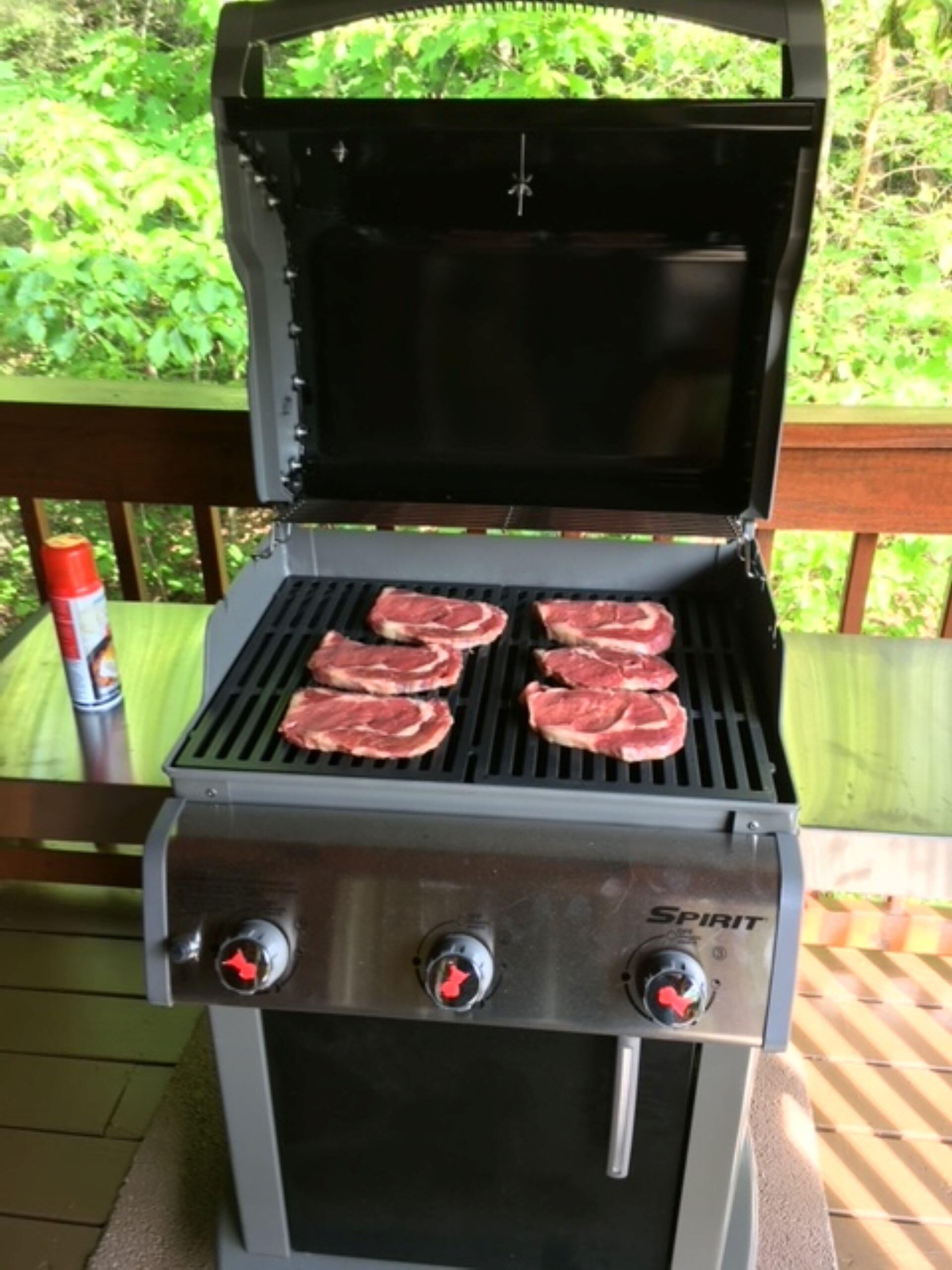 Un gril sur lequel cuisent quatre steaks.