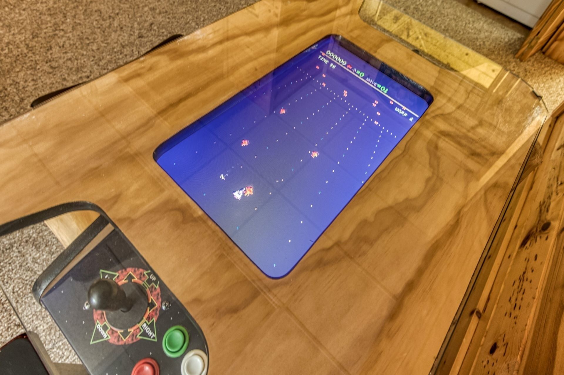 Puisesta pöydästä löytyy tabletti, jossa näkyy peli, sekä ohjain ja muutama painike.