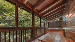 A wooden deck with a picnic table and benches, surrounded by a wooden railing, overlooking a forested area. - Er309- George's- Great Location- Close To Town 5 Bedroom Cabin by RedAwning (Pigeon Forge)