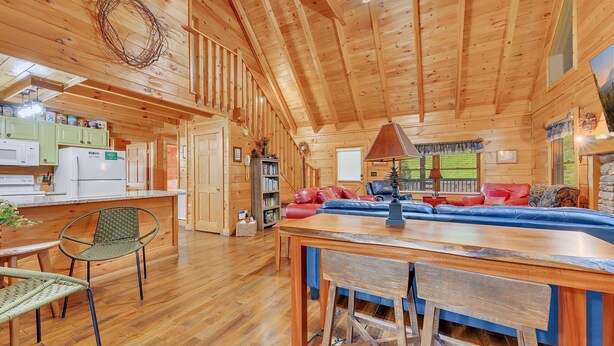 A spacious wooden cabin interior with a kitchen, dining area, and living room. - Er309- George's- Great Location- Close To Town 5 Bedroom Cabin by RedAwning (Pigeon Forge)