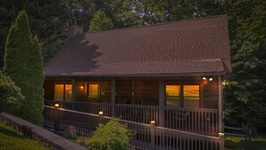A cabin with a porch, a chimney, and a fenced yard. - Er309- George's- Great Location- Close To Town 5 Bedroom Cabin by RedAwning (Pigeon Forge)
