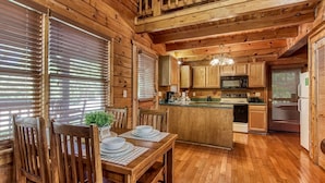 L’intérieur d’une cabane en bois comprend un coin repas, une cuisine et un petit îlot central.