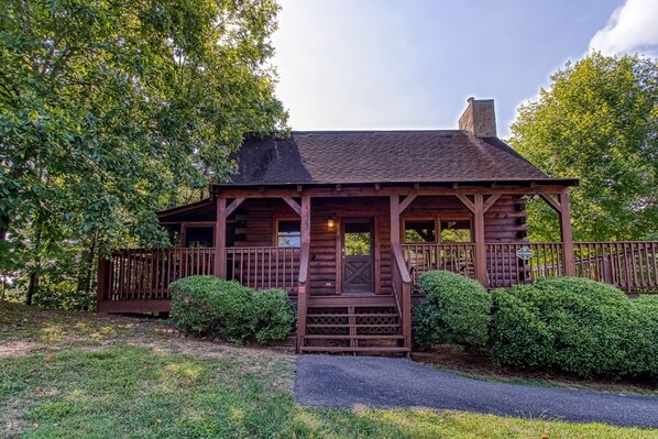 A rustic log cabin with a porch, a chimney, and a sign indicating it is a lodge. - Er5 - Log Heaven - Great Location! Close To All The Action! 1 Bedroom Cabin by RedAwning (Pigeon Forge)