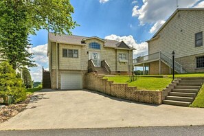A two-story house with a front garage, a covered porch, and a staircase leading to the second floor. - Olde Beau Cottage MAGNIFICENT VIEWS! (Glade Valley)