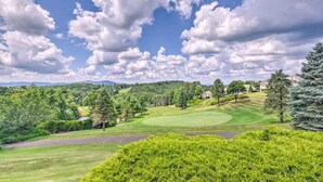 Un terrain de golf sous un ciel dégagé, parsemé de quelques nuages.