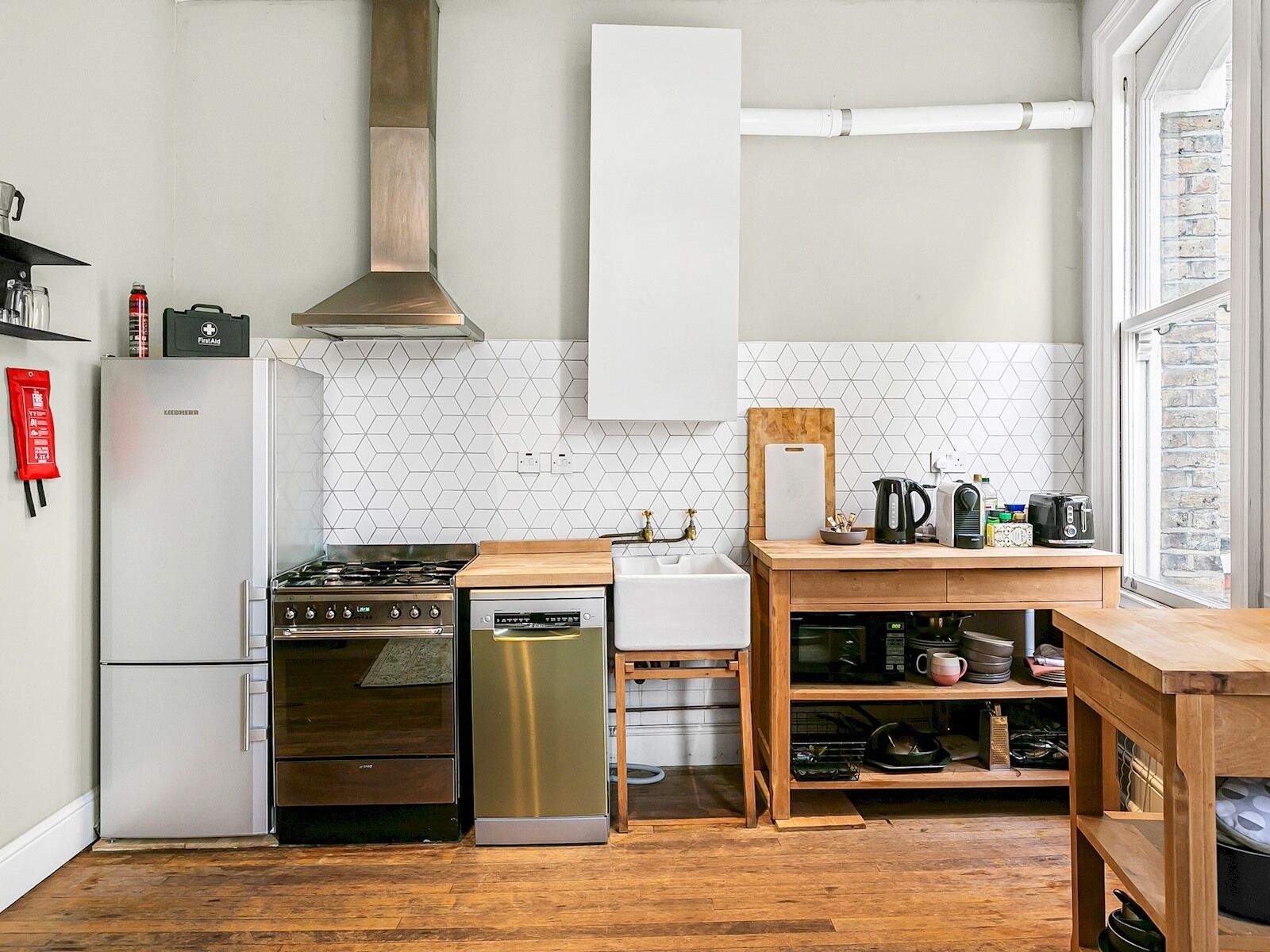 A compact kitchen with a gas stove, oven, dishwasher, and a small sink.