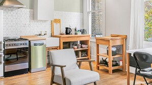 A compact kitchen with a gas stove, a refrigerator, and wooden furniture. - Charming and Spacious Apartment in Central Brixton - Pass the Keys (London)