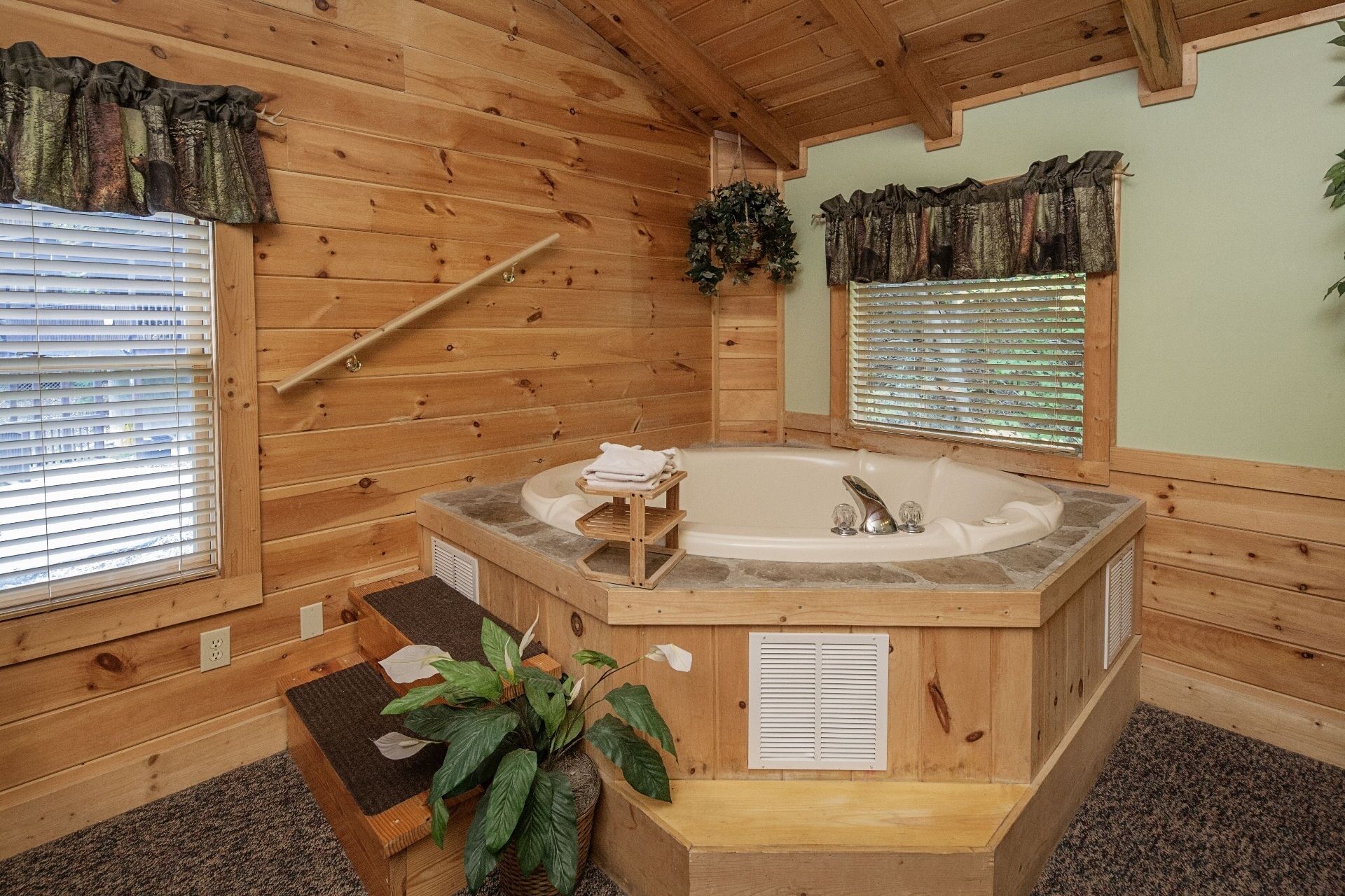 Een houten blokhut met een hottub, houten wanden en ramen met zonwering.