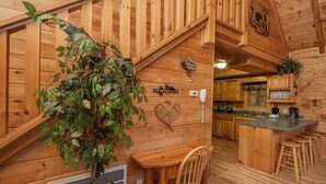 A wooden interior with a staircase, a bar area, and a kitchen. - Er302 - Best Of Times Great Location-close To Town 2 Bedroom Cabin by RedAwning (Pigeon Forge)