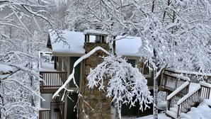 A snow-covered building with a stone facade, wooden balconies, and a snow-covered roof. - Gatlinburg Views A Unique Cabin Mountain Views Expansive Decks Adjacent To Gatlinburg & Ski Lodge 1 Bedroom Cabin by RedAwning (Gatlinburg)