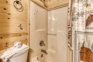 A wooden interior with a shower area, a towel rack, and a curtain with a forest design. - Er45 - Tin Pan Alley - Great Location. Just Across From Swimming Pool! 2 Bedroom Cabin by RedAwning (Pigeon Forge)