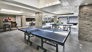 Ett rymligt inomhusområde med ett bordtennisbord, sittplatser och en servering där man kan köpa enklare mat och dryck.
