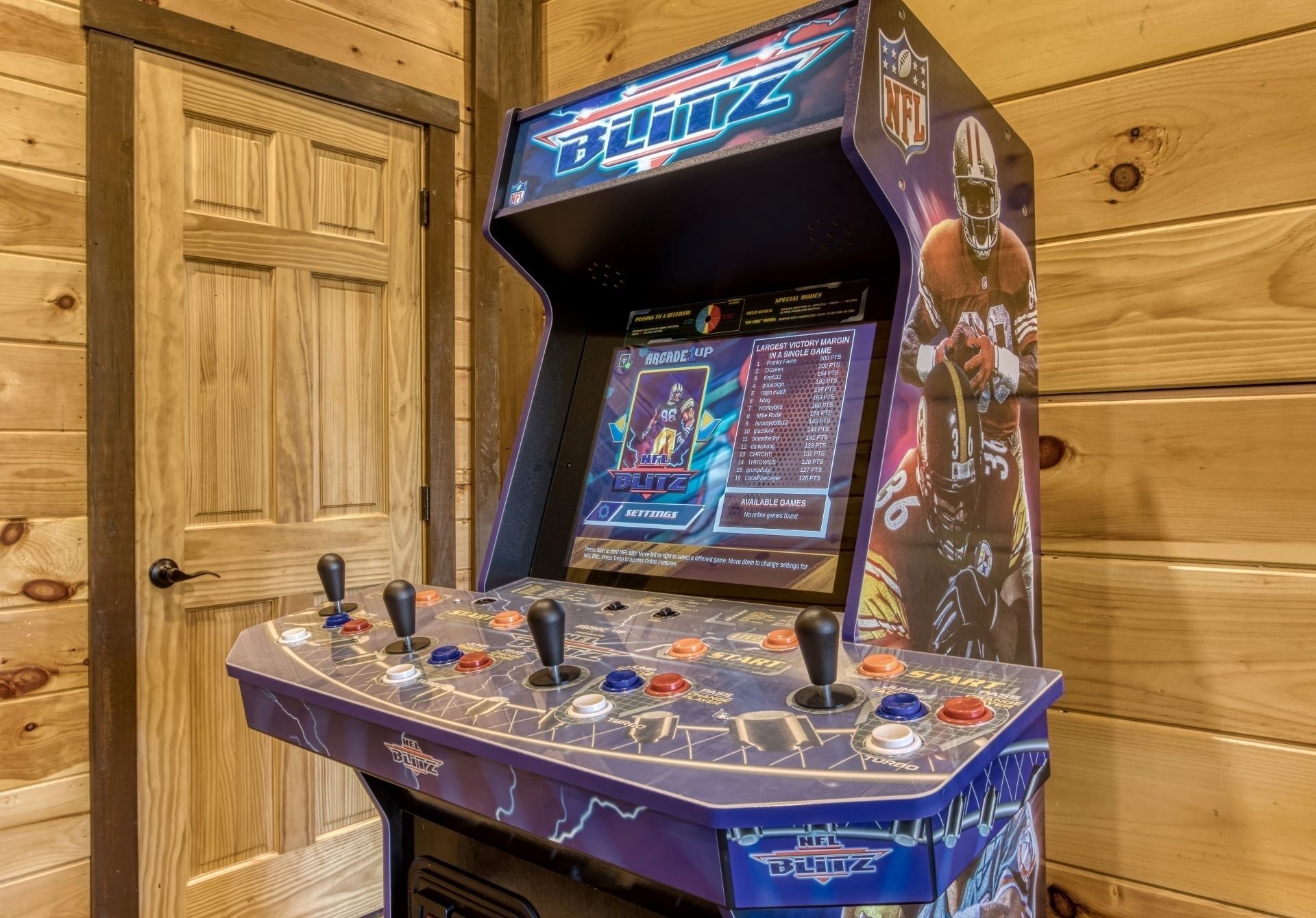 Een NFL Blitz spelcomputer met meerdere joysticks en een scherm waarop instellingen van het spel worden weergegeven.