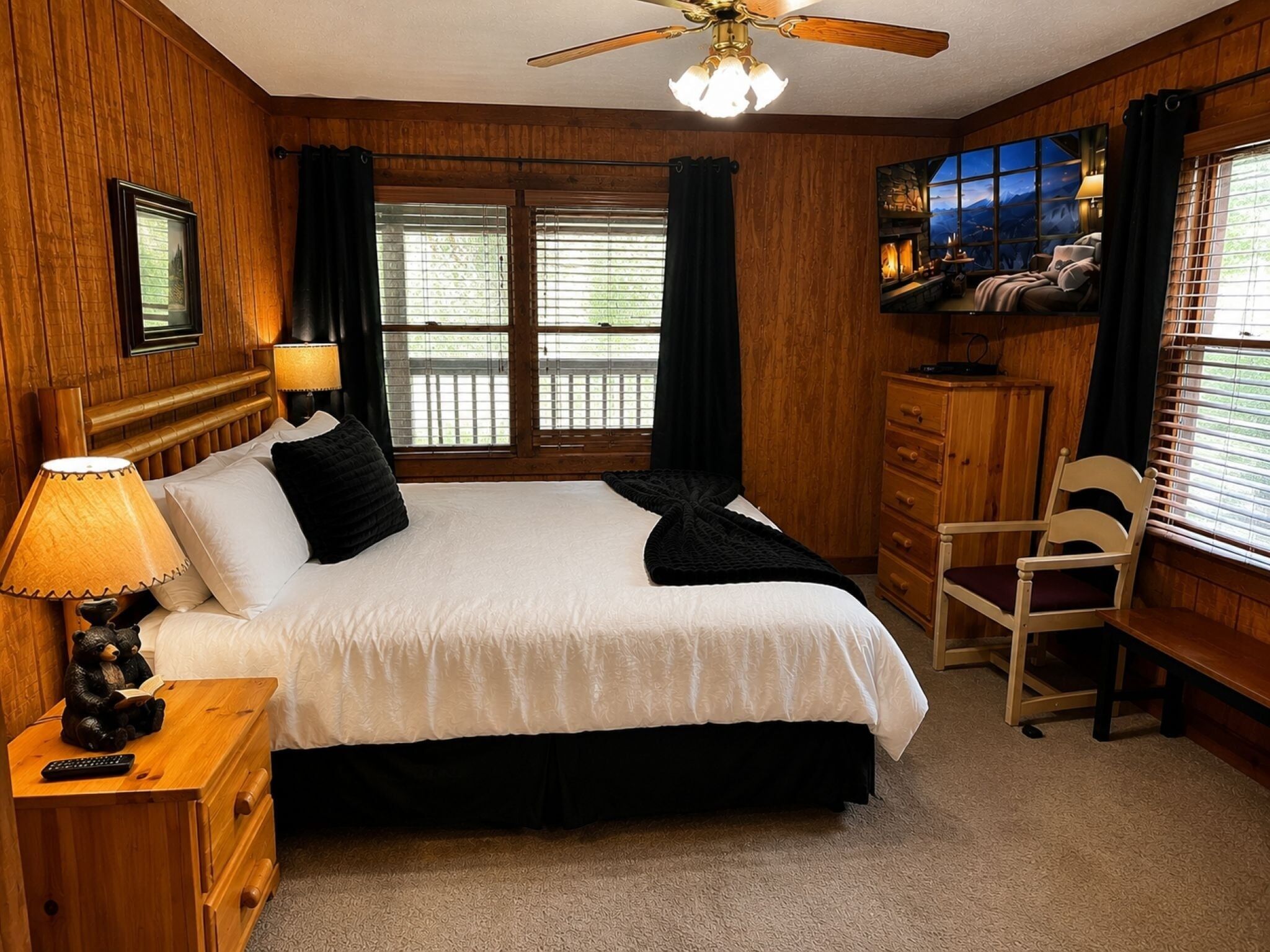Een slaapkamer met houten lambrisering, een bed, nachtkastje, stoel en televisie.