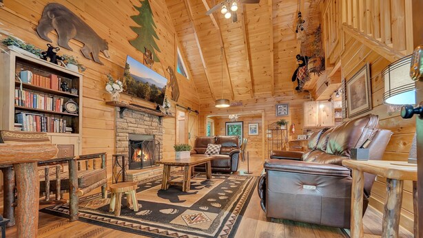 A cozy cabin interior with a fireplace, leather furniture, and wooden decor. - Er258- Sweet Memories Great Location- Close To Town 5 Bedroom Cabin by RedAwning (Pigeon Forge)