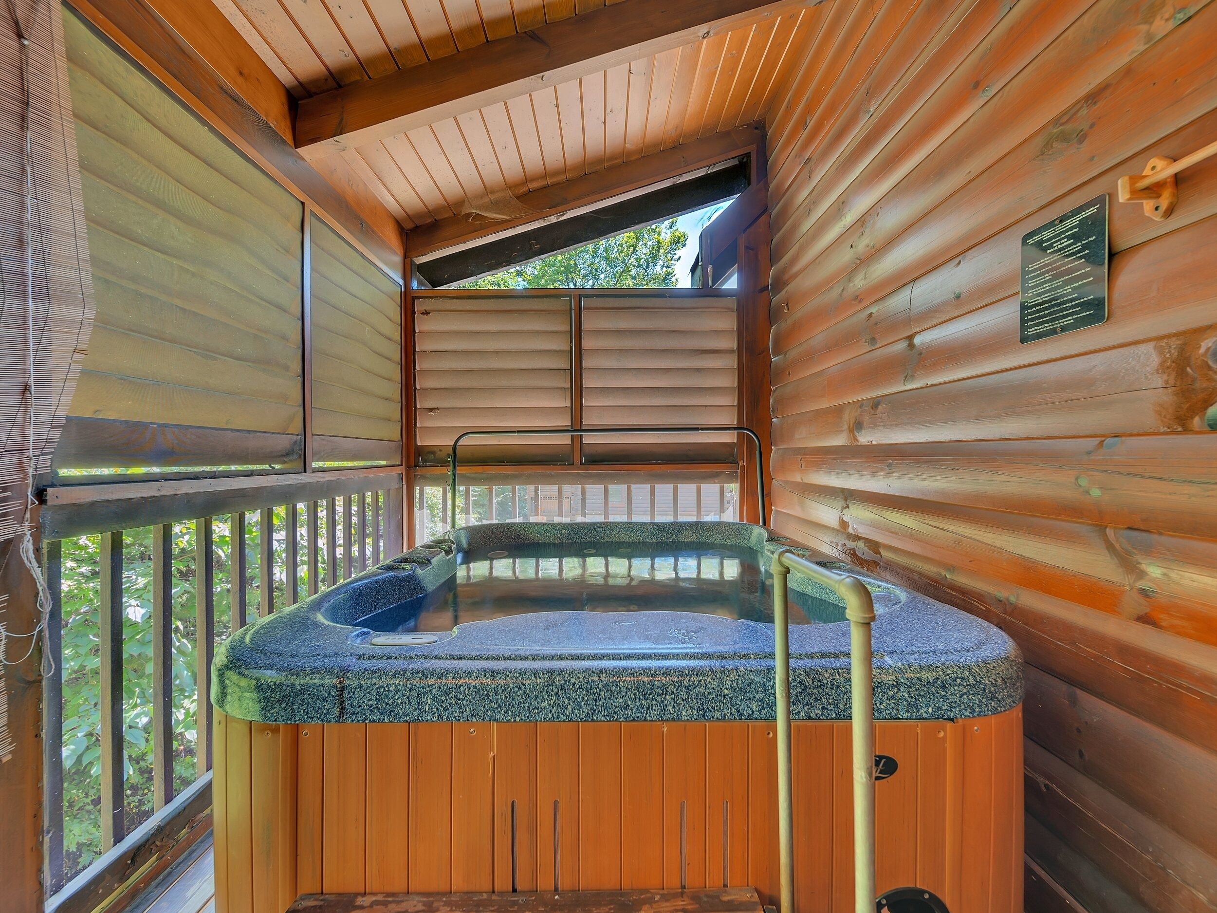 Une cabane en bois dotée d’un bain à remous, de murs en bois et d’un balcon.
