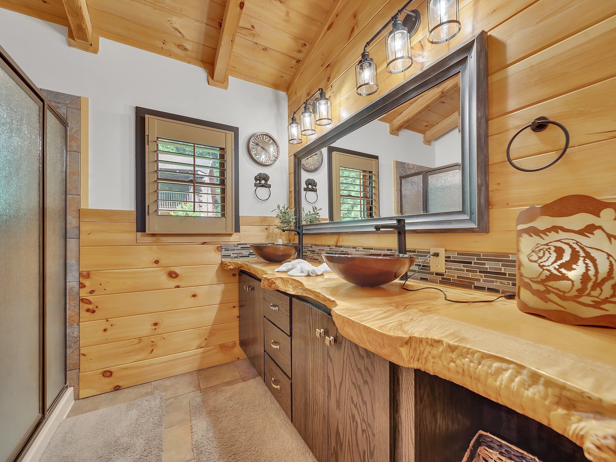 A wooden interior with a kitchen counter, a large mirror, and a bowl.