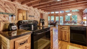 A wooden cabin kitchen with a blender, stove, and dishwasher. - Er1 - Smoky Mountain Escape Great Location - Close To Town! 3 Bedroom Cabin by RedAwning (Pigeon Forge)