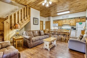 A wooden interior with a staircase, a dining area, and a kitchen.