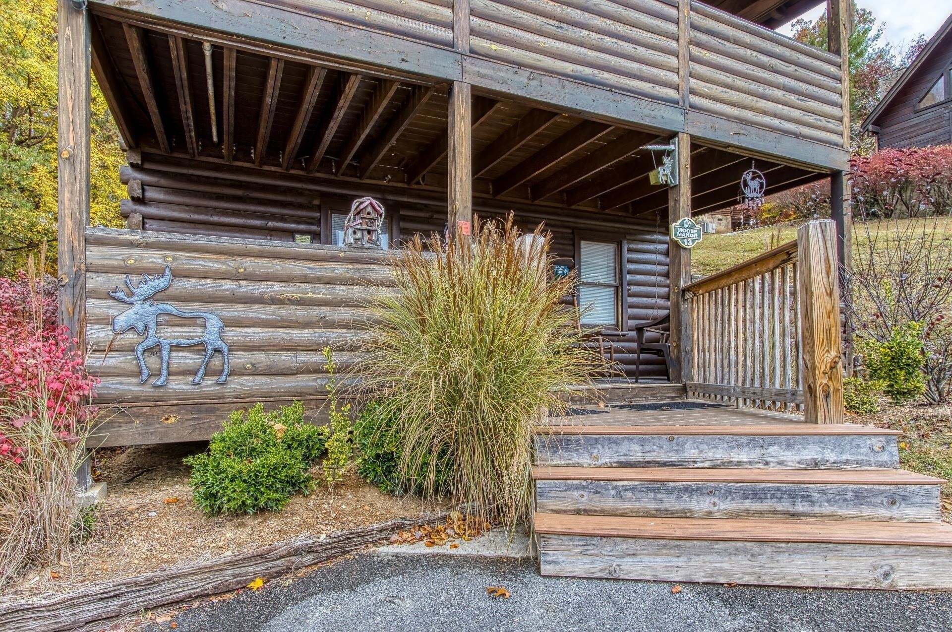 Una rustica baita di legno con un portico in legno, una scultura di alce e un cartello che indica che fa parte del Moose Mountain Lodge.