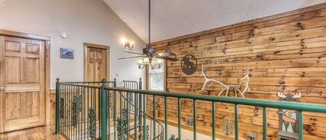 Interior de madera con escalera, ventilador de techo y varias decoraciones en las paredes, incluyendo figuras de animales.