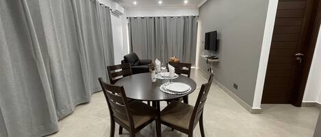 A dining area with a round table, chairs, and a ceiling fan.