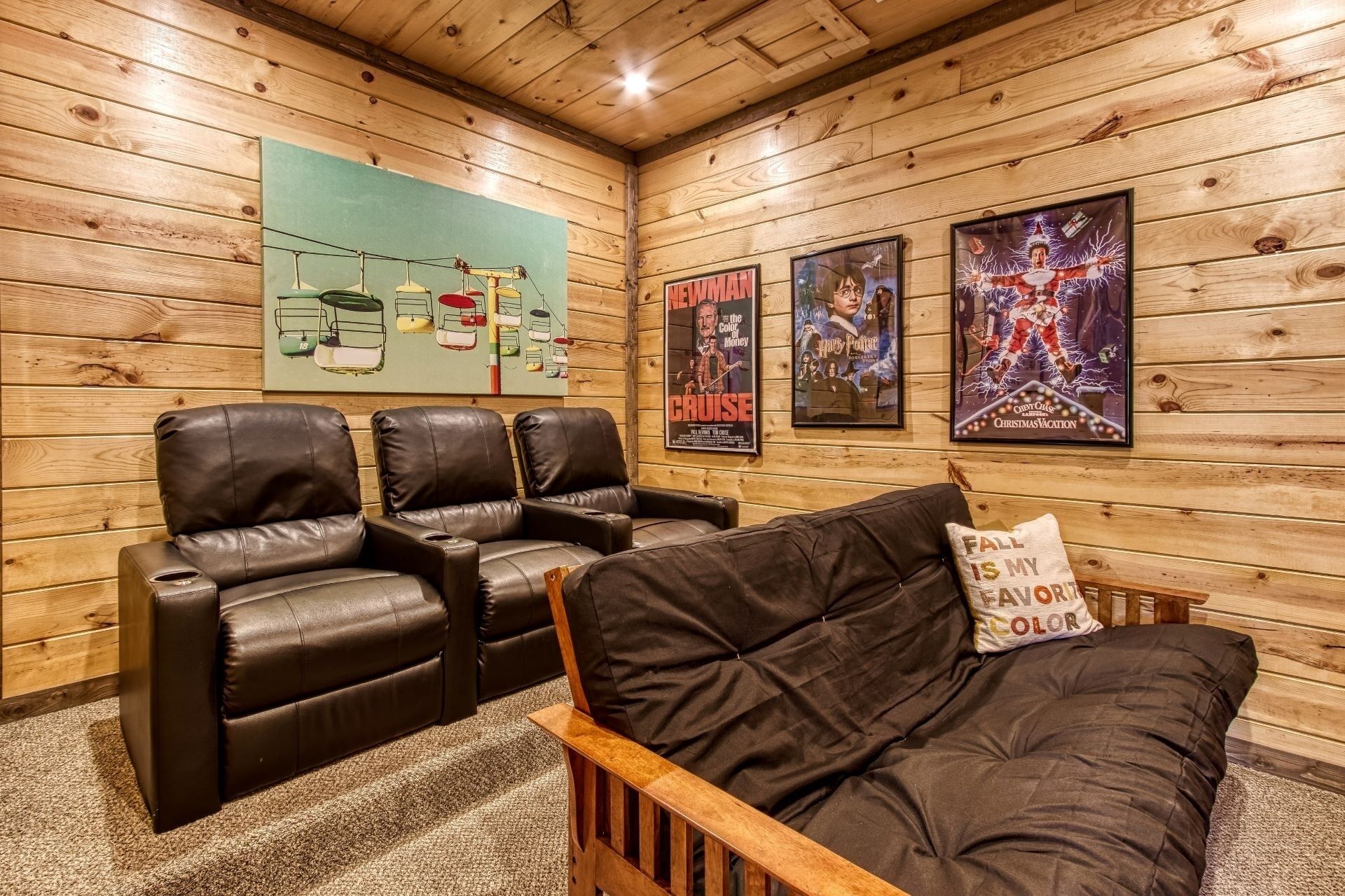 Una habitación acogedora con paredes de madera, un sofá de cuero y tres sillones de cuero. Hay carteles en la pared, incluyendo uno de 'Cruise' y otro de 'Harry Potter'.