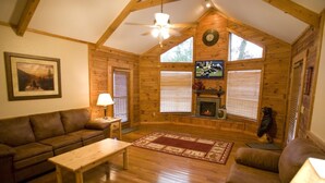A cozy living room with a wooden ceiling, a fireplace, a television, and a couch. - Er79 - Robyn's Nest - Great Location. Close To All The Action! 2 Bedroom Cabin by RedAwning (Pigeon Forge)