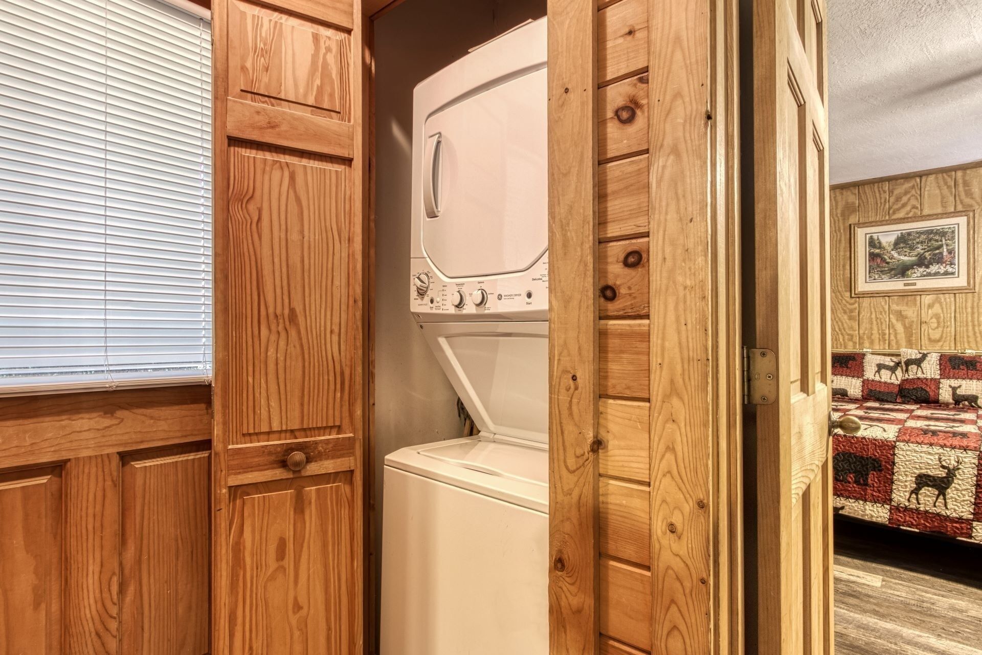 A laundry room with wooden cabinets and a white washing machine.