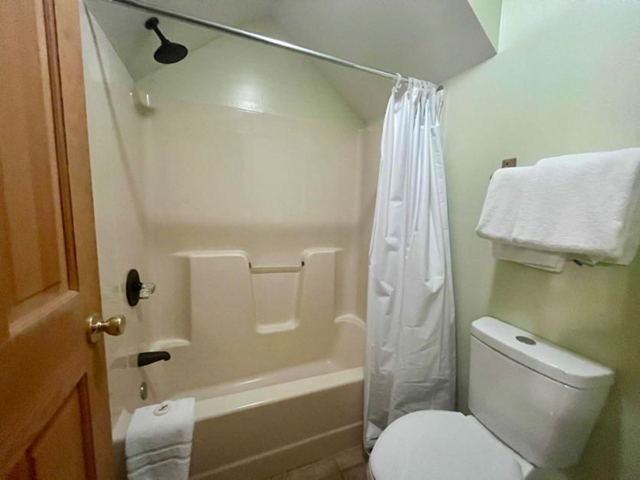 Een badkamer met een bad, toilet en een douchegordijn.