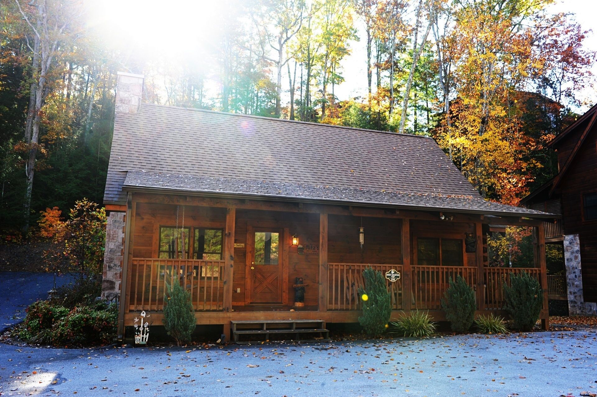 A wooden cabin with a porch, stone foundation, and a sign indicating it's a restaurant.