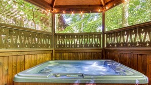 A wooden hot tub with a glass enclosure, surrounded by wooden panels and string lights. - Er96 - Squirrel's Leap - Great Location! Close To Town! 2 Bedroom Cabin by RedAwning (Pigeon Forge)